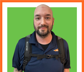 SERVPRO employee in front of green background