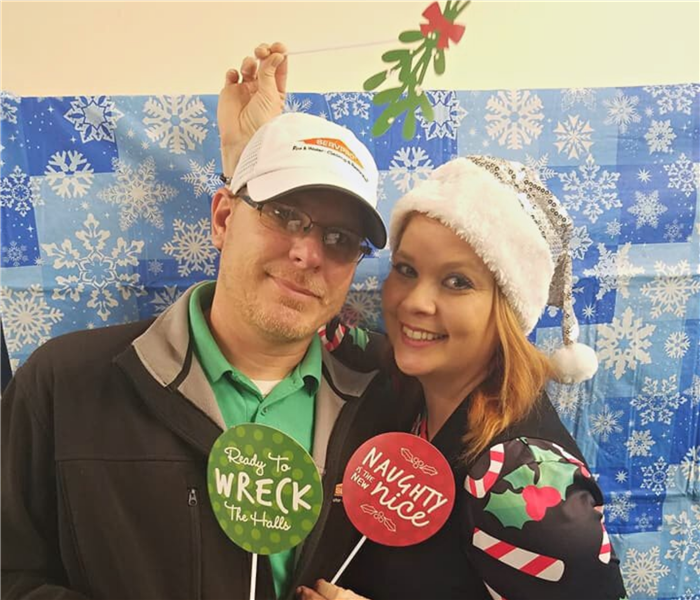 Debra and Chuck Tucker, SERVPRO of Bartlett/Cordova employees dressed in holiday attire posing for photo