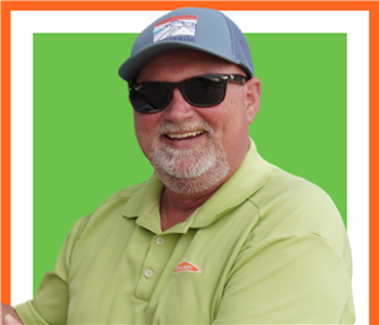 SERVPRO employee male with hat on and posing outside